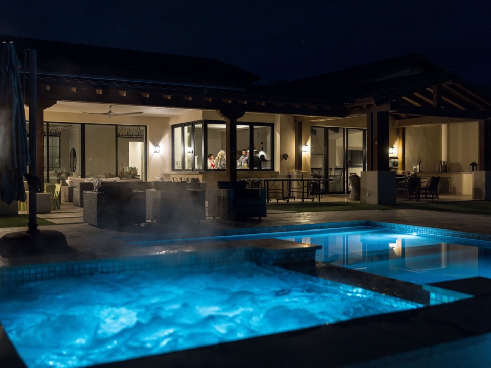 The pool and house lit up at night