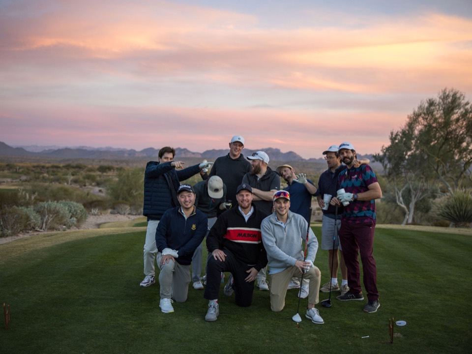 The crew celebrating on the tee box at sunset