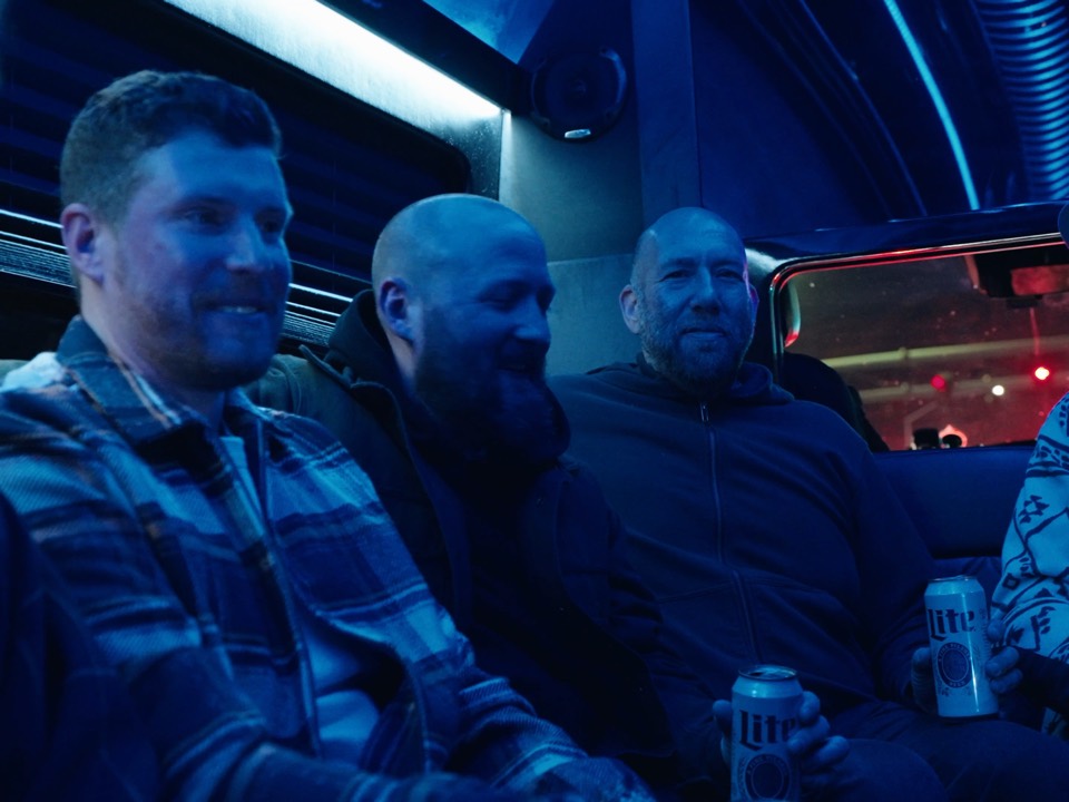 The crew on the party bus under blue lights on a night out