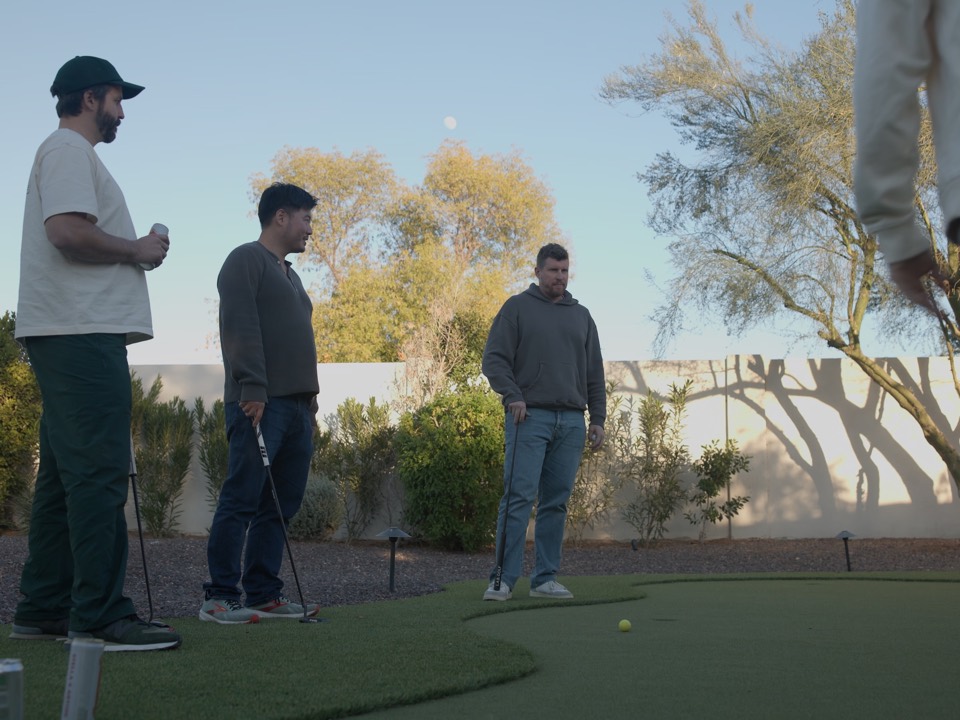 Three guys putting on the backyard green at the house